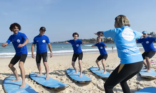 A class of happy participants learning to surf