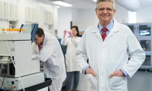 Professor Roger Reddel standing in a lab coat in research facilities at Westmead
