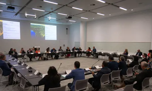 International delegation of country representatives Seated In A Square Boardroom Setup At Conference